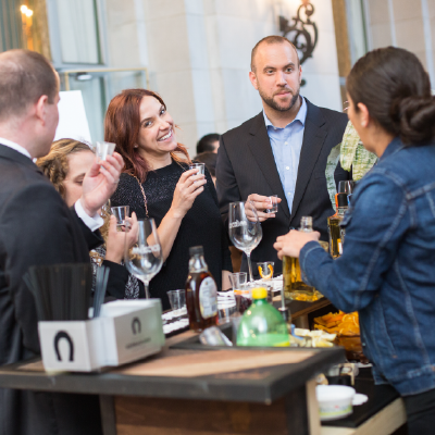 Group of guests enjoying a social and gastronomic experience with drinks at Gourmex East Bay.